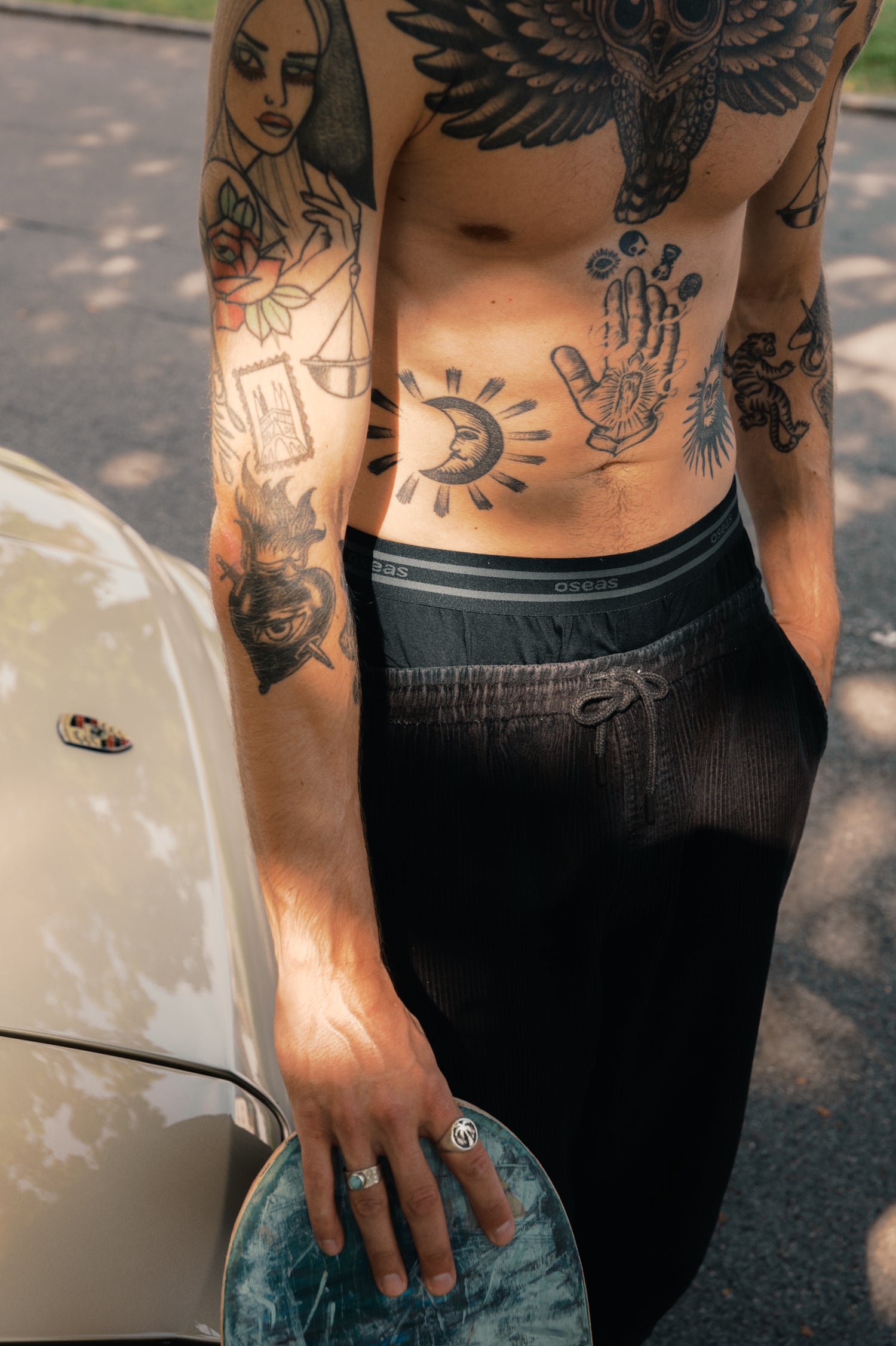Mann trägt schwarze Boxershorts aus TENCEL™ Lyocell in weiter Passform vor einem Auto.